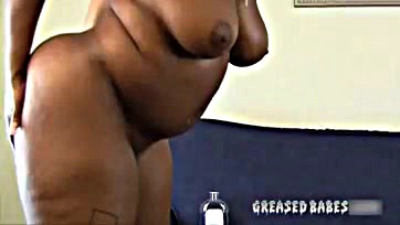 A black woman shakes her massive, oiled booty