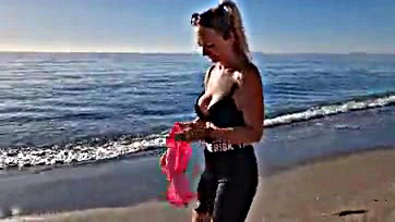 Milf removes bra during beach morning stroll