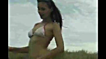 Foxy teen flaunts her bare booty on sandy shore