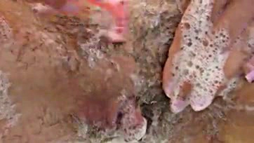 Amateur woman shaves her hairy vulva in close-up