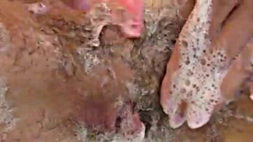 Amateur woman shaves her hairy vulva in close-up