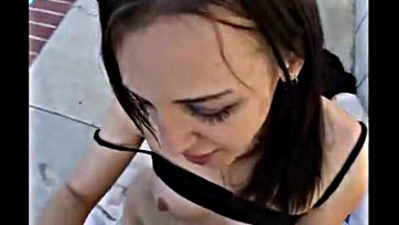 Brassy brunette sucks cock on public street