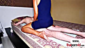 A teenage Thai girl massages a large white penis