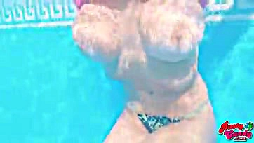 Big-boobed blonde teen flaunts her massive tits at pool