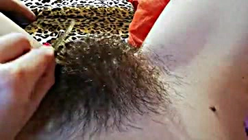 Explicit video showcases hairy vulva and prominent clitoris