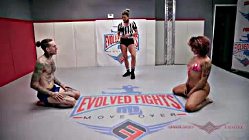 Two women engage in explicit sex on a wrestling mat