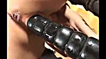 Sunny uses a thick black dildo on herself